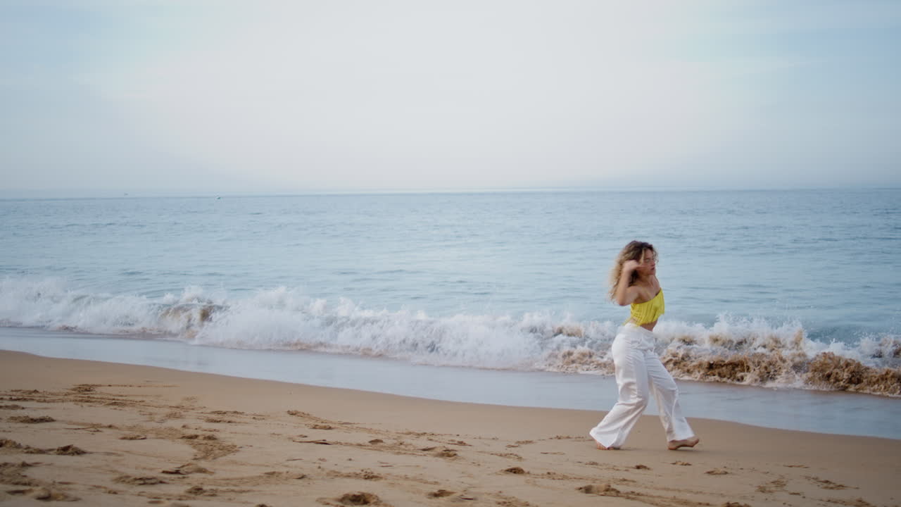 모래 해변에서 현대적인 스타일의 감각적인 여자 춤 improvisation. 여자 회전