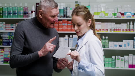 mujer joven hablando con un hombre mayor en la farmacia.