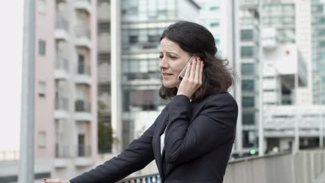 mujer de negocios seria hablando por teléfono inteligente