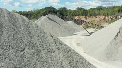 daylight aerial panning of limestone piles and conveyor belt at quarry