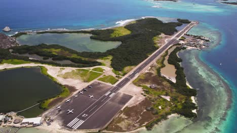 The-narrow-runway-on-erera-los-roques-with-clear-blue-waters,-aerial-view