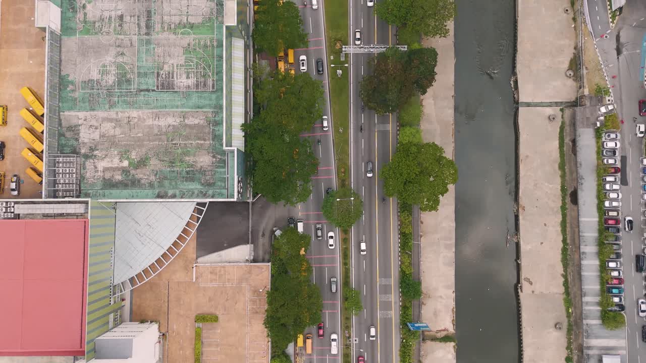 Top-down drone shot of Kuala Lumpur, Malaysia, revealing downtown streets, traffic, river, and urban structures in a bustling city environment