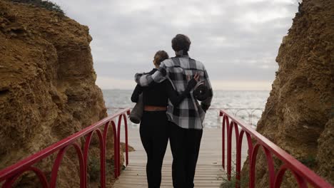 una pareja disfrutando de un paseo panorámico por la costa, llevando sus esteras de yoga
