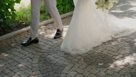 bride and groom in elegant attire walking hand in hand outdoors, enjoying a peaceful moment together