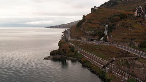 Aerial-of-highway-and-train-track-in-mountains-next-to-lake