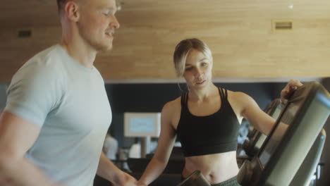man training on treadmill with female gym instructor
