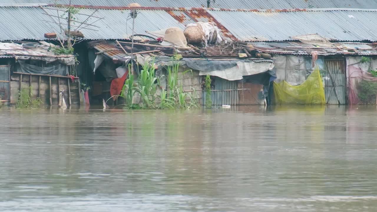 Floodwaters Swamped the Tin Shed Houses in the Riverbank Slum in Bangladesh, South Asia - Pan Up Shot