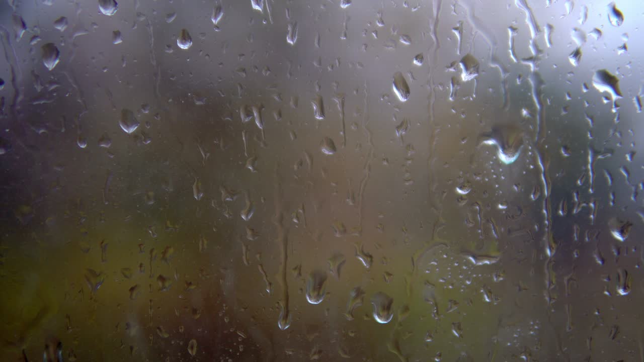 clima nublado y lluvia fuera de la ventana. ventana húmeda y brumosa con piedras que gotean.