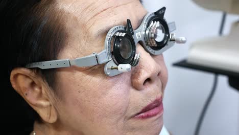 elderly woman taking an eye test to check her visual acuity in an optical clinic in bangkok, thailand