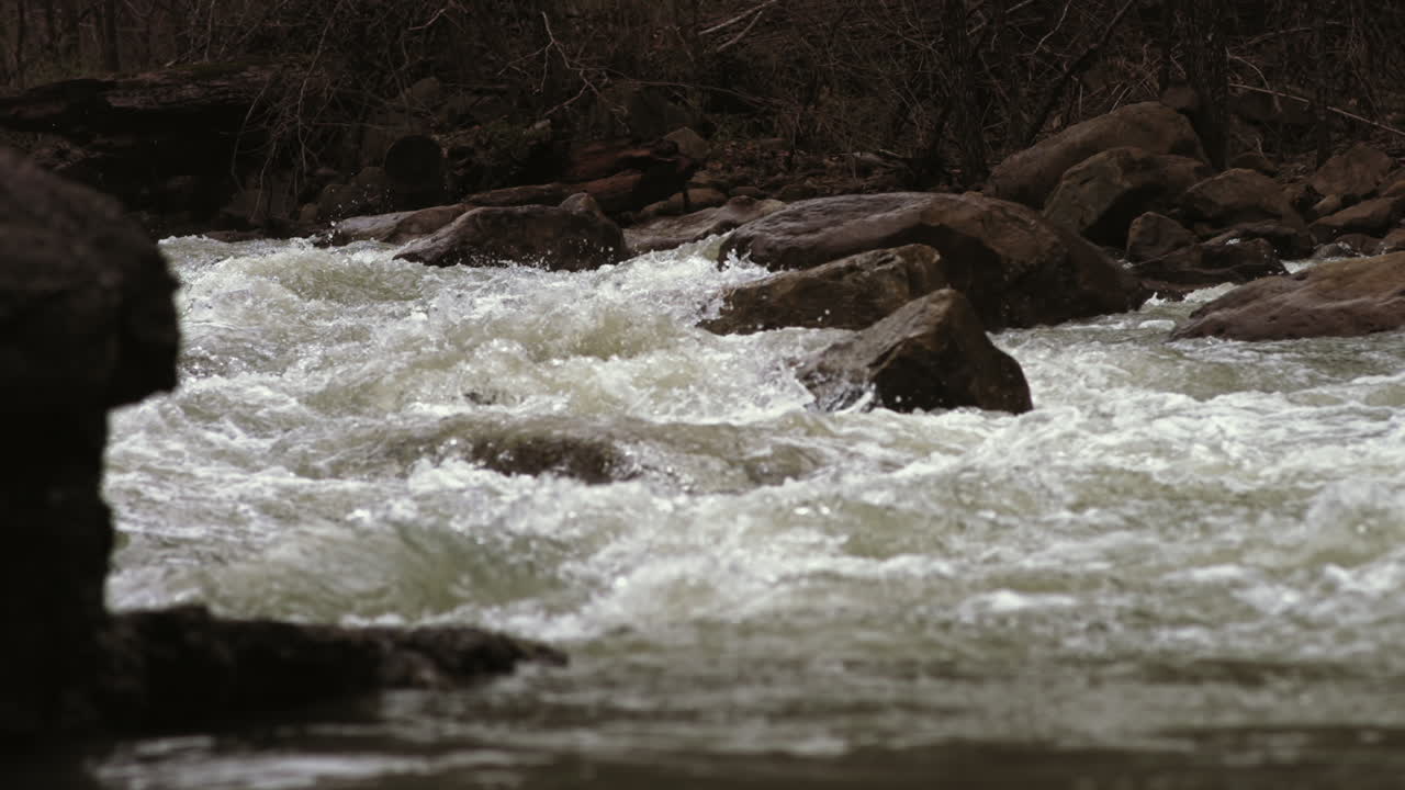 Ampio rallentatore di acqua che si muove velocemente e schizza contro una roccia in una rapida nel Suck Creek a Chattanooga, Tennessee