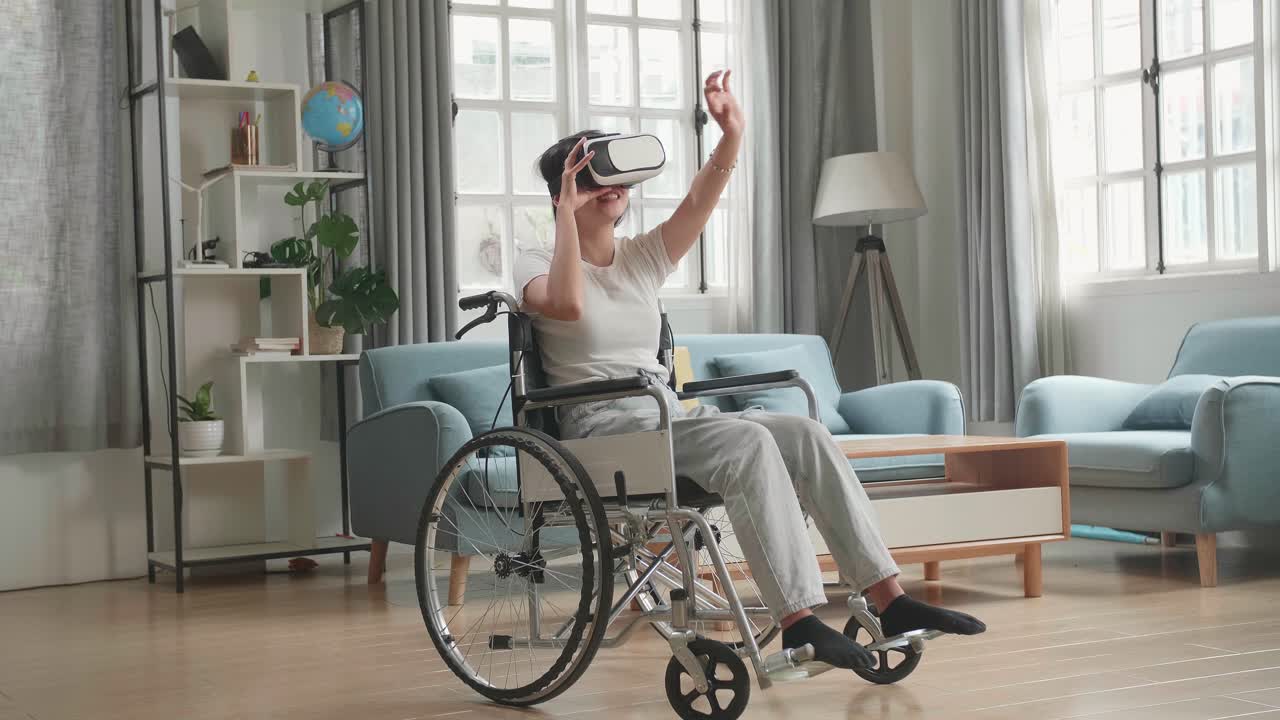 mujer asiática graciosa sentada en una silla de ruedas mientras usa gafas de realidad virtual en casa