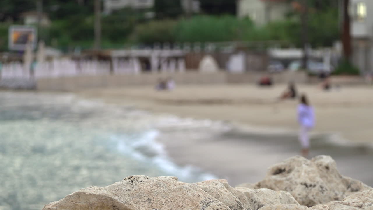 Blurred view of people swimming and relaxing on the beach on the French Riviera