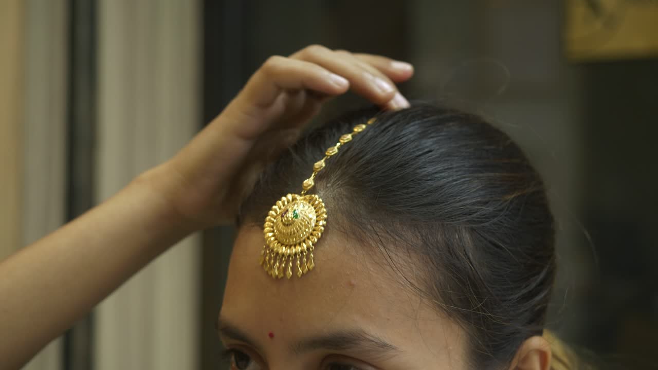 Young and beautiful south asian woman wearing head gold jewellery, Closeup