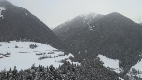 Tormenta-De-Nieve-De-Mal-Humor-Oscuro-En-Los-Alpes-Italianos,-Puedes-Ver-Un-Valle-Frío-Y-Un-Pueblo