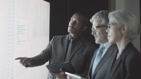 Confident black finance expert giving consultation to his team