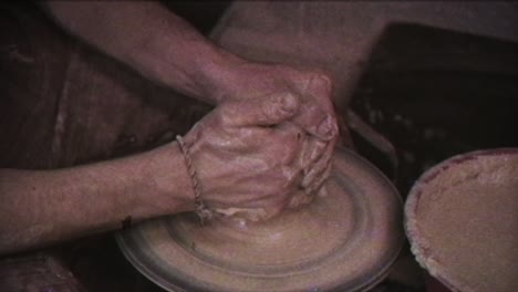 the potter makes a jug of clay. vintage effect. a man makes a vase on a potter's wheel