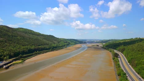 low, rising aerial video of the newry river and mourne mountains in warrenpoint, county down, northern ireland, uk on a bright and sunny day. filmed in 4k, 60fps and with rec709 color.