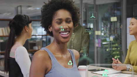 animation of ecology icons and data processing over diverse colleagues talking in office