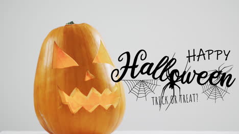 happy halloween text banner with spider icon over halloween pumpkin against grey background