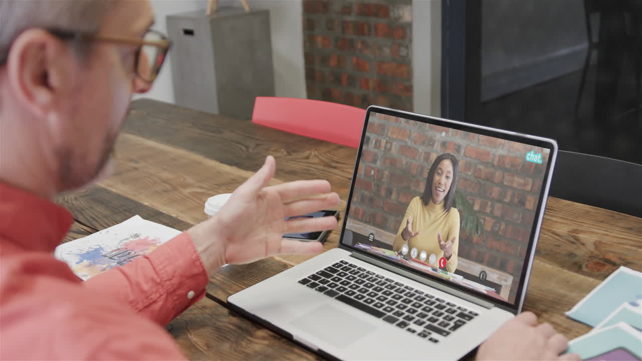 Caucasian businessman on laptop video call with caucasian female colleague on screen