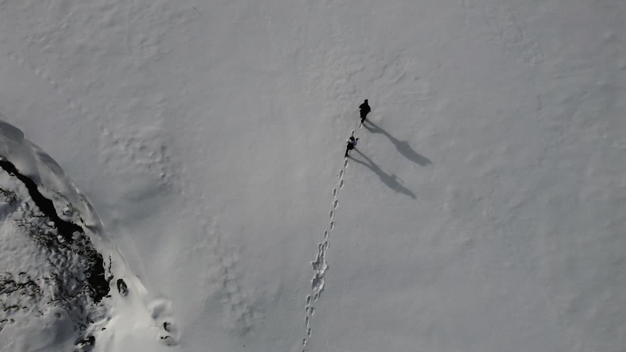 caminando en la nieve profunda, filmado desde arriba con un dron
