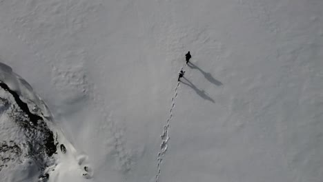 Caminando-En-La-Nieve-Profunda,-Filmado-Desde-Arriba-Con-Un-Dron