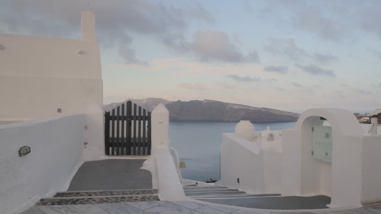 un callejón griego con vistas a la majestuosa vista de la caldera en santorini