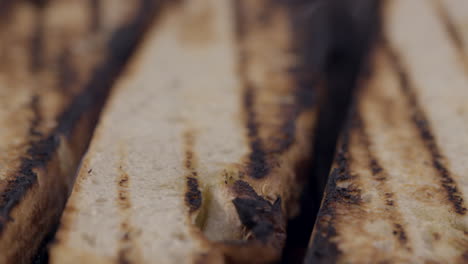 closeup-of-artisan-hand-crafted-bread-toasting-on-a-grille-in-an-upscale-restaurant-kitchen