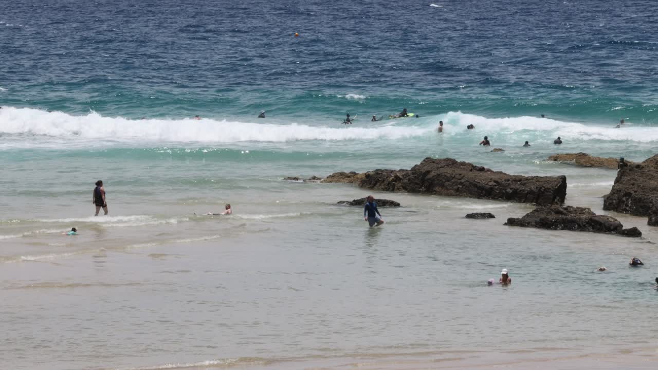 사람들이 해변에서 수영하고 휴식을 취하고 있습니다.