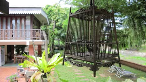 Traditioneller-Thailändischer-Vogelkäfig,-Der-In-Einem-Baum-Mit-Gartenhintergrund-Hängt