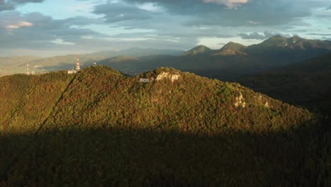 Una-Exuberante-Y-Verde-Cadena-Montañosa-Durante-La-Puesta-Del-Sol-Con-Sombras-Proyectadas-Sobre-El-Paisaje,-Vista-Aérea