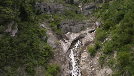 establishing aerial view following glacial mountain stream in lush woodland valley slopes of, provo, utah