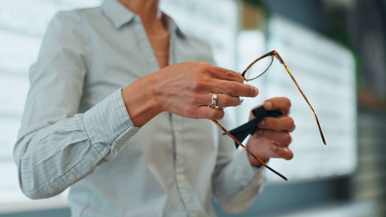Woman cleaning eyeglasses with a cleaning cloth
