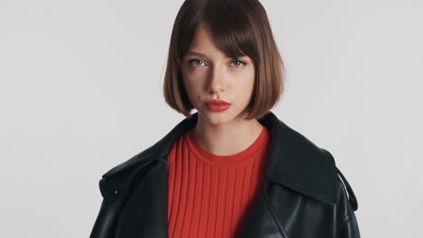 modelo con chaqueta negra y suéter rojo posando en el estudio