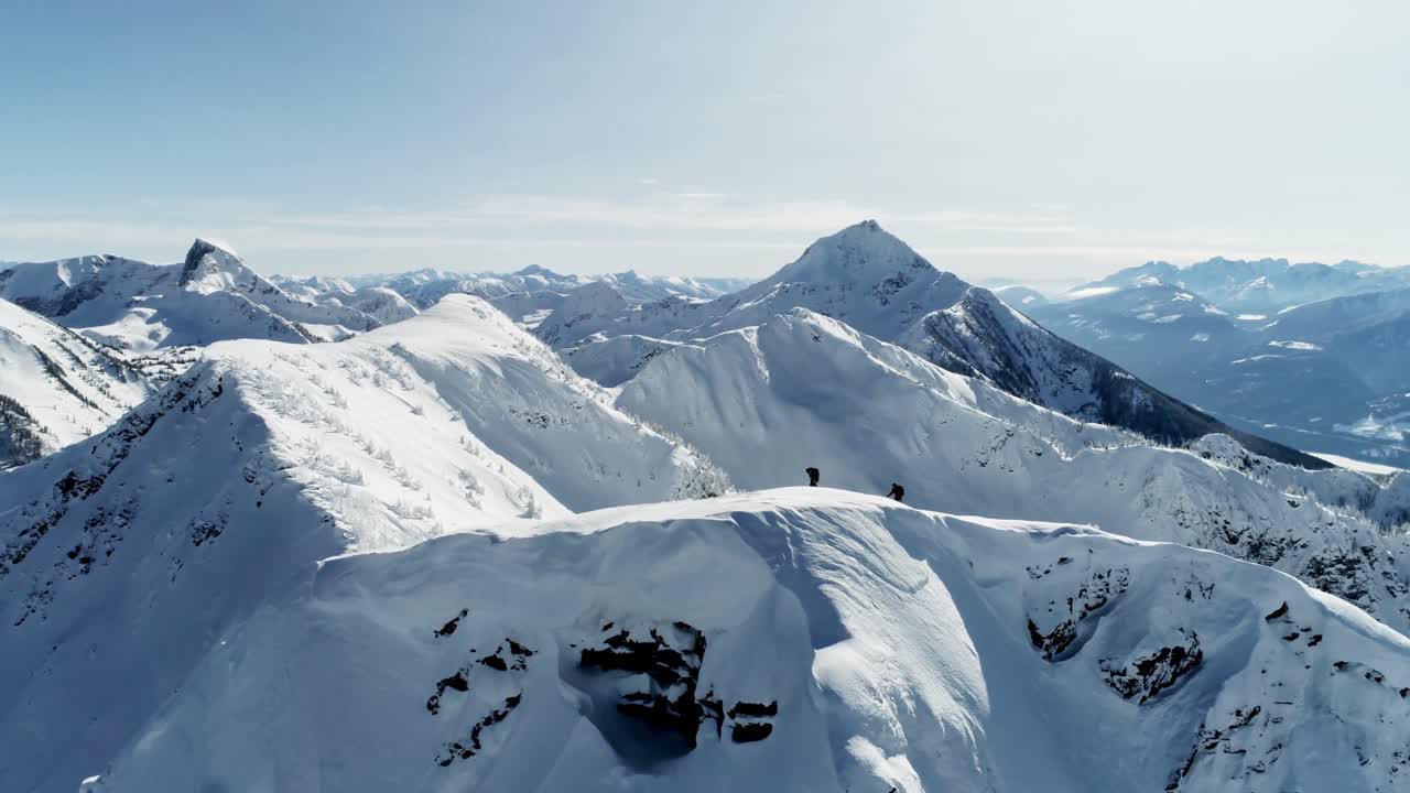 Sciatori che camminano su una montagna innevata 4k