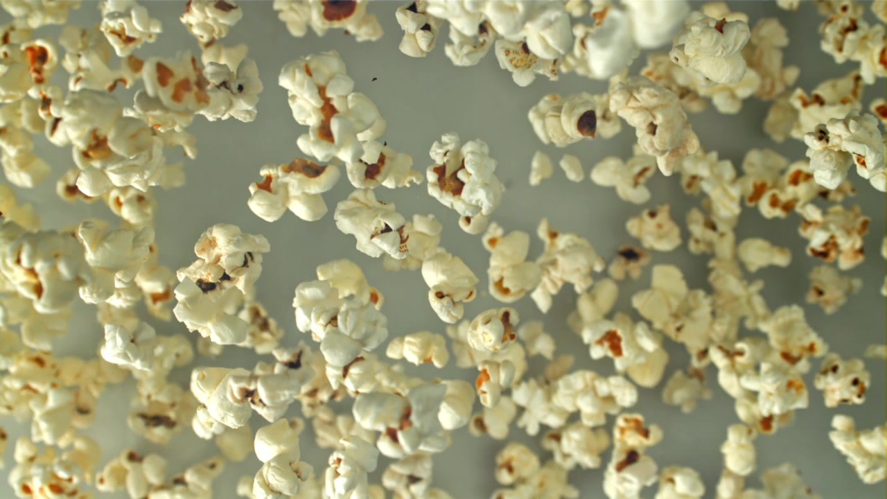 Popcorn che cade al rallentatore su uno sfondo chiaro