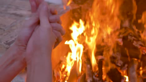 woman-warming-her-hands-at-a-barbecue