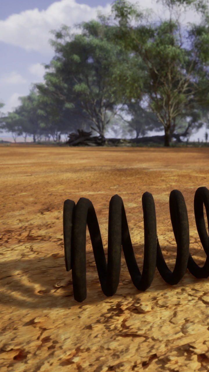 Unique black coil resting on cracked earth under clear blue sky in nature