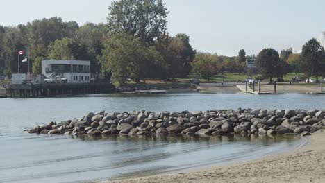 Muelle-De-Piedra-Junto-A-Una-Pequeña-Playa-Con-Olas-Pequeñas