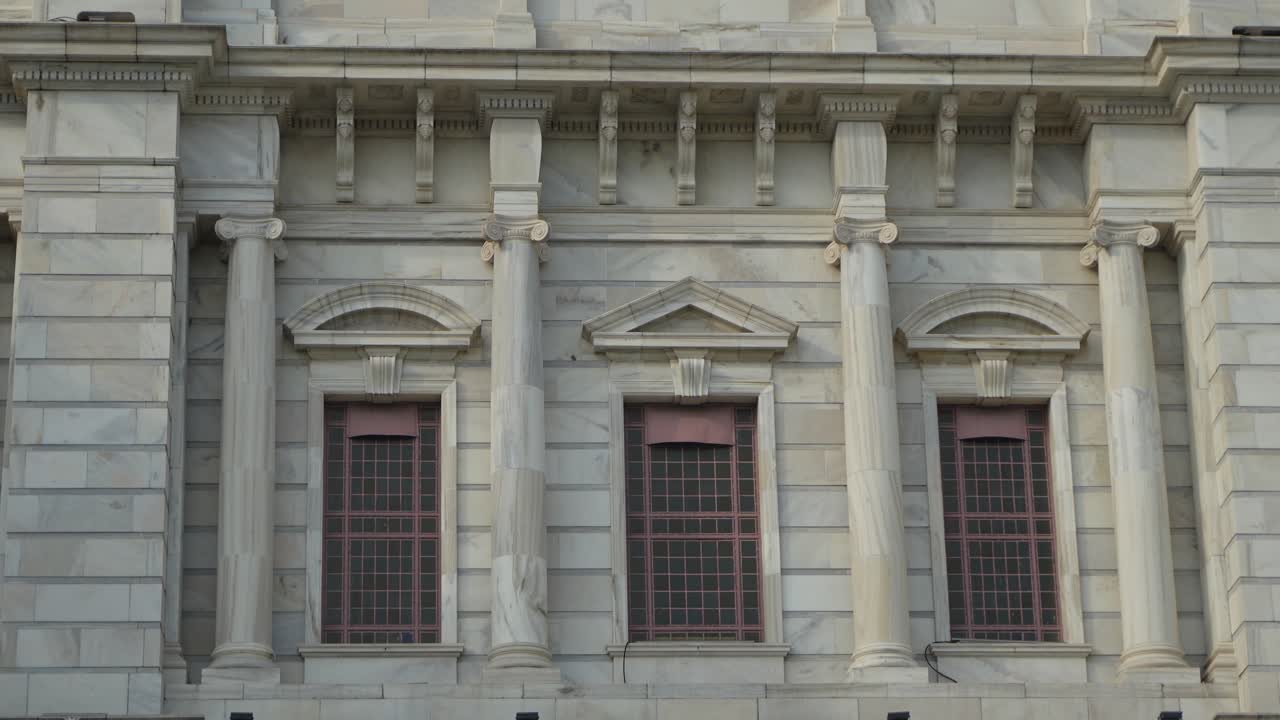 White Marble Building Facade with Classical Columns and Windows