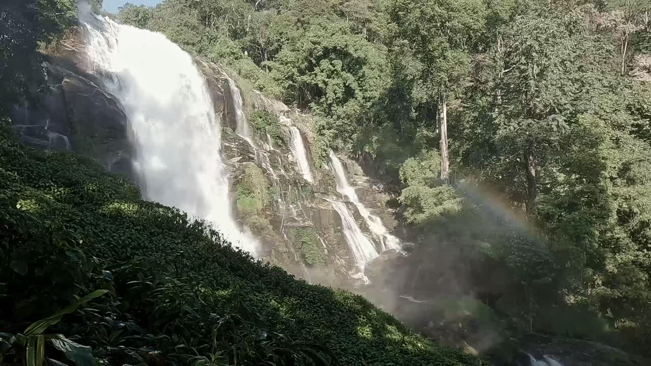 Panning right to the majestic Siriphum Waterfall with rainbow forming in the mist, Doi Inthanon National Park in Chiang mai Thailand