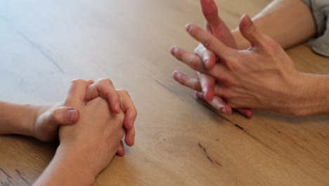 colleagues sit at wooden table discussing work in office