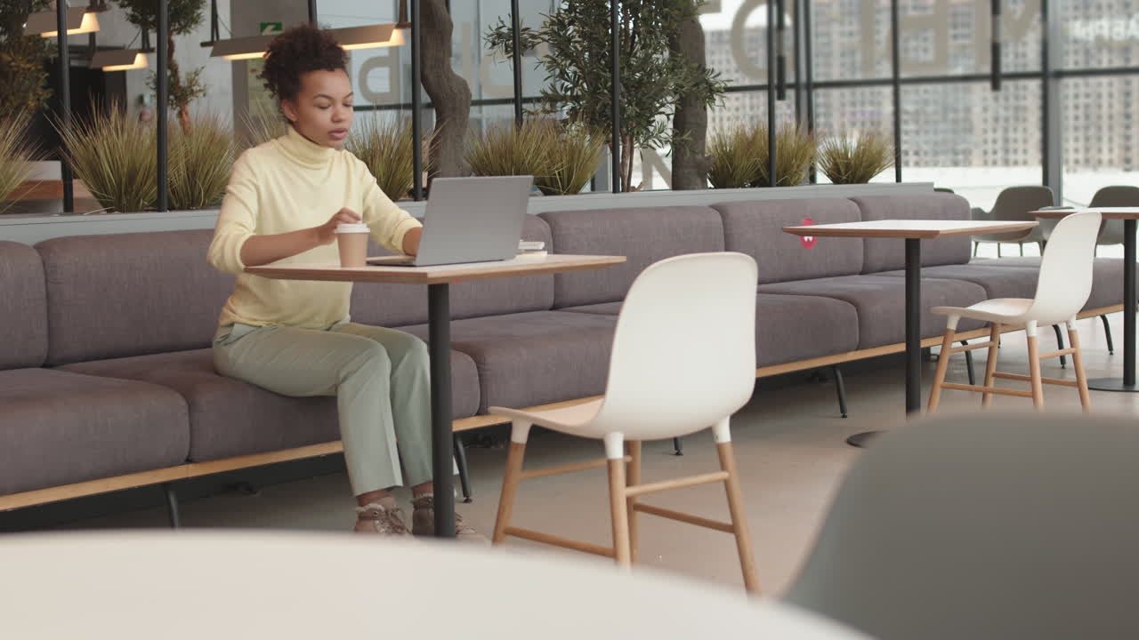 Biracial Woman Drinking Coffee in Coworking