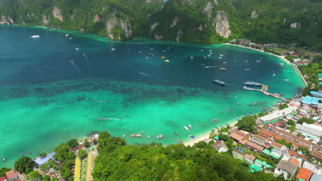 Vista-Aérea-De-La-Playa-Paraíso-Tropical-En-Tailandia-Drone-Revela-La-Isla-Koh-Phi-Phi-En-La-Provincia-De-Krabi-Famoso-Destino-De-Viaje-De-Vacaciones-Tailandés,-Velero-Amarrado-En-La-Bahía-De-Aguas-Cristalinas-Prostinas