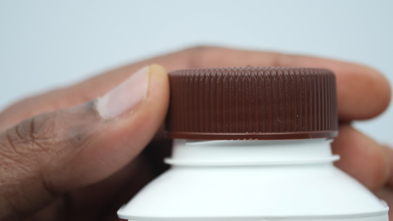 mano abriendo una botella de leche