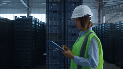 female warehouse worker checking shipment boxes inspecting delivery package