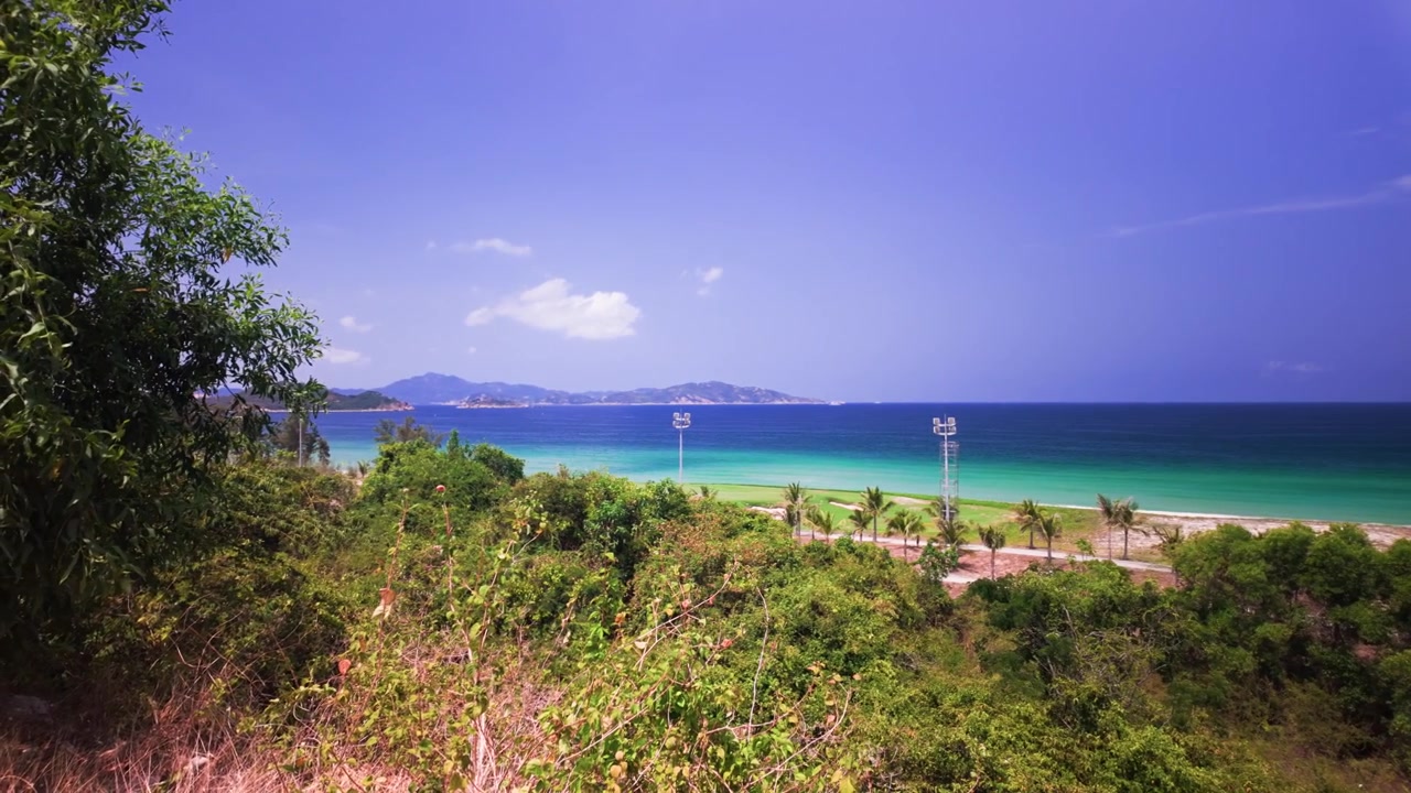 Pesisir Ninh Thuan di Vietnam menampilkan pemandangan laut yang luas. Bukit-bukit menjulang di atas lanskap, menciptakan bingkai alami. Ini menunjukkan keindahan lokasi ini pada siang hari.