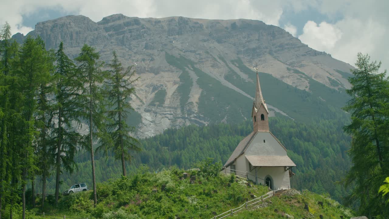 전체 샷, 이탈리아의 언덕과 교회 옆에 주차된 자동차, 배경에 있는 산맥의 아름다운 전망