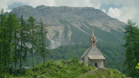 Tiro-Completo,-Coche-Aparcado-En-La-Ladera-De-La-Colina-Y-La-Iglesia-En-Italia,-Vista-Panorámica-De-La-Cordillera-En-El-Fondo