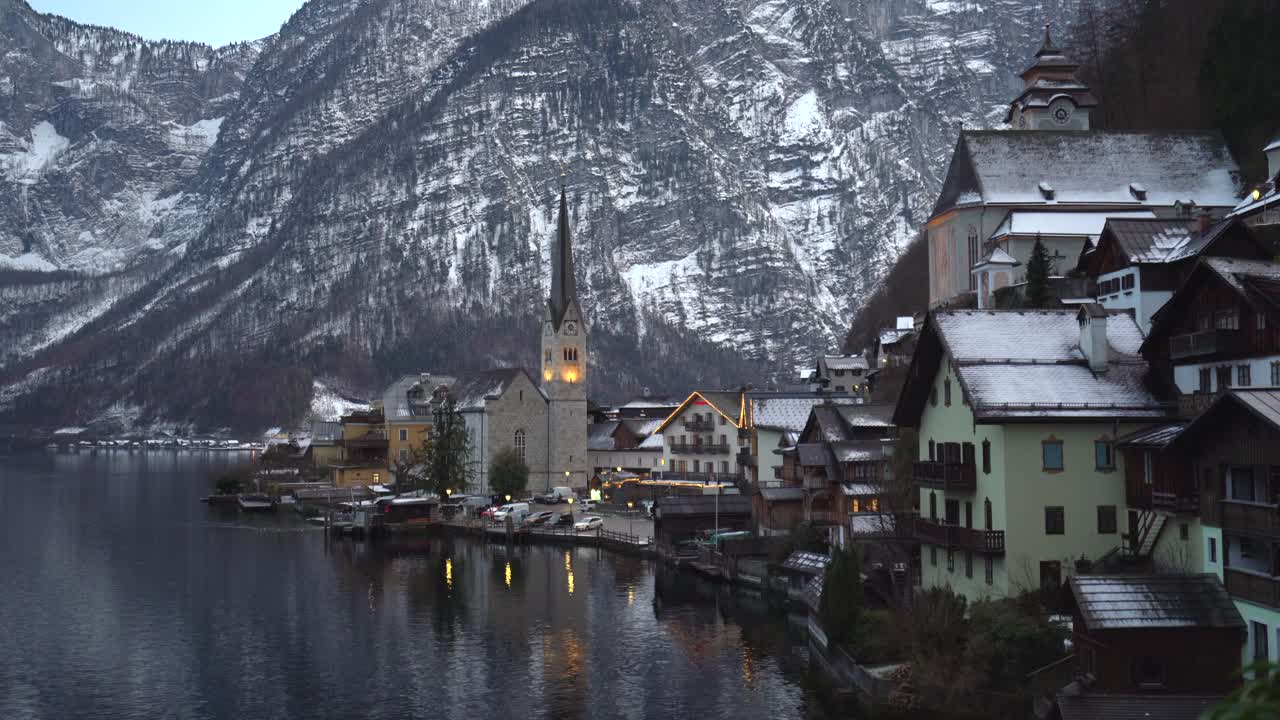 Static shot of Picturesque Hallstatt town covered by snow by the lake, Austrian Alps